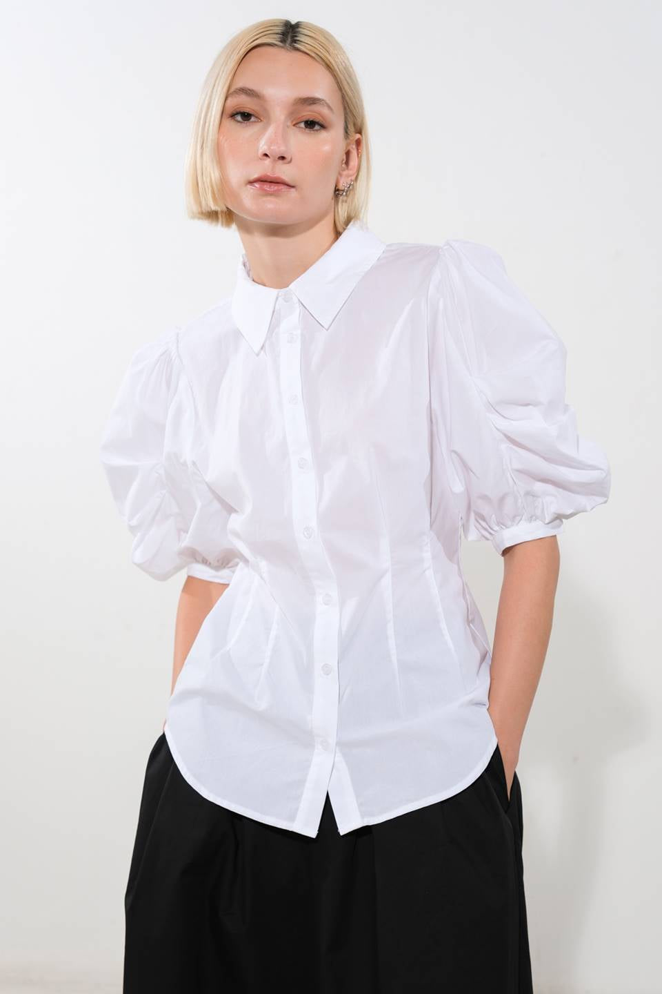 A solid woven top featuring shirt collar, button down and elbow sleeve