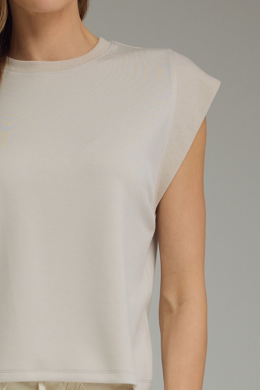 Solid round neck cap sleeve top featuring ribbed trim