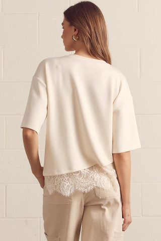 Solid short sleeve knit top featuring scallop lace hem detail