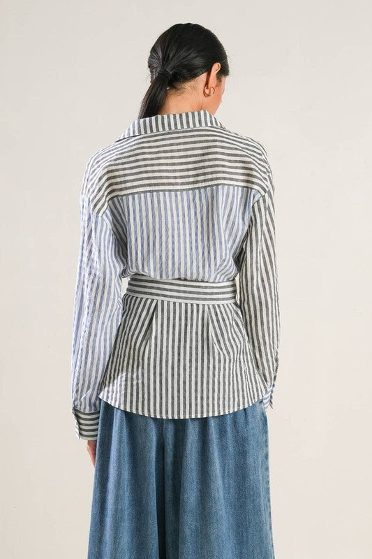 A striped woven top featuring surplice neckline, long sleeve, side button and peplum