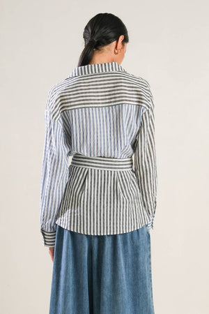 A striped woven top featuring surplice neckline, long sleeve, side button and peplum