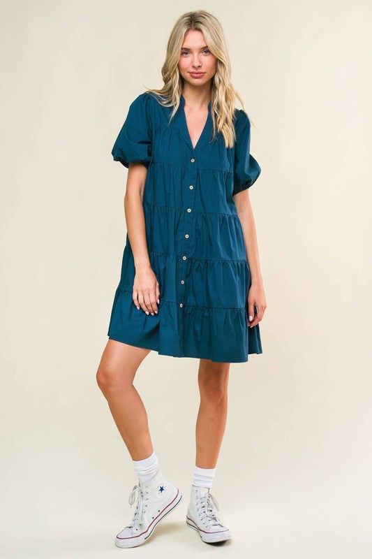 A solid woven mini dress featuring V neckline, short puff sleeve