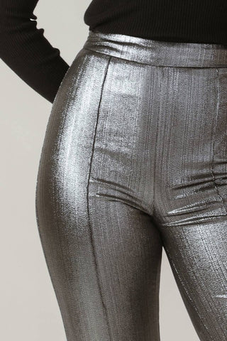 A foil coated woven pant featuring side zipper and flare leg