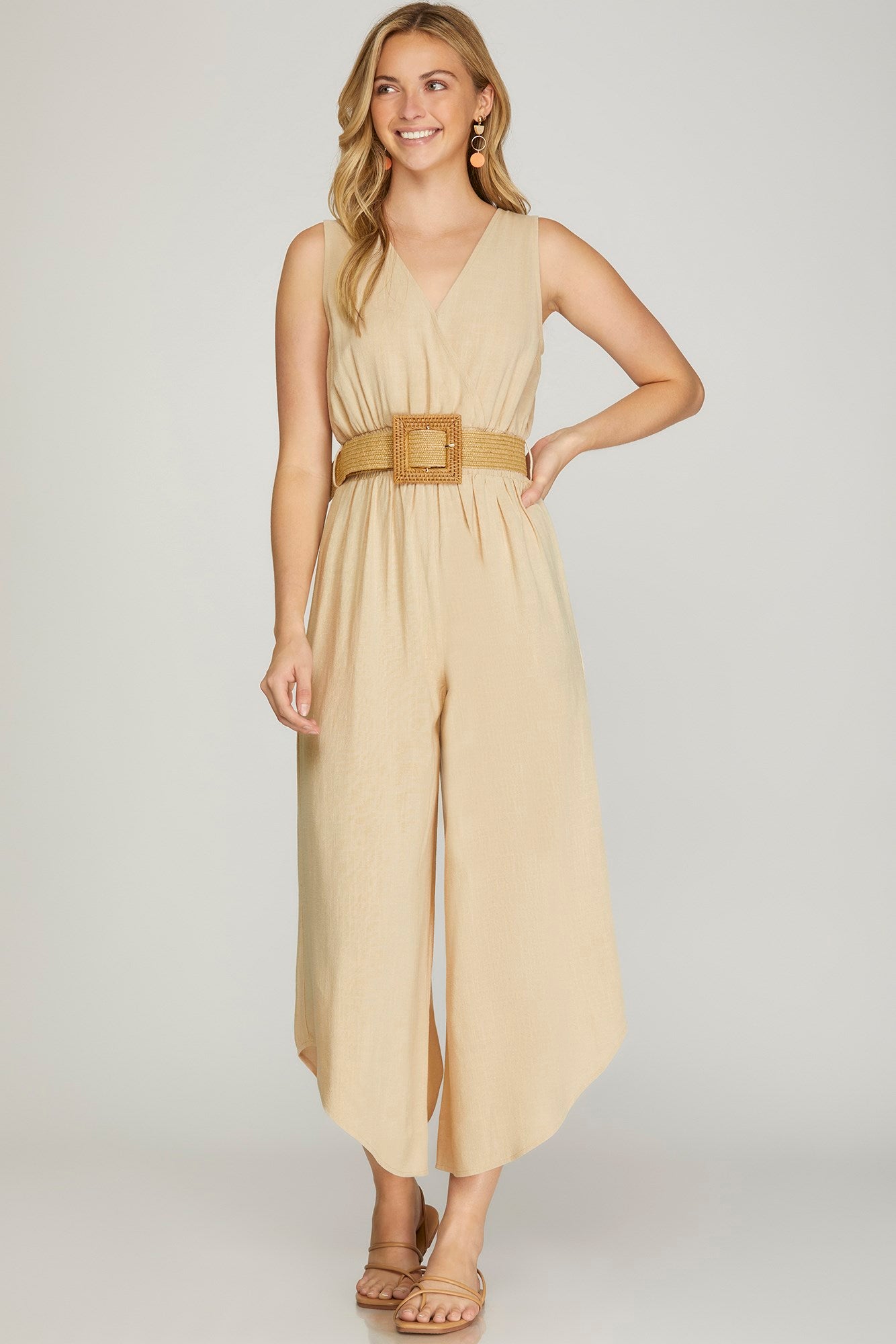 SLEEVELESS SURPLICE WOVEN JUMPSUIT WITH SMOCKED WAIST AND BELT DETAIL