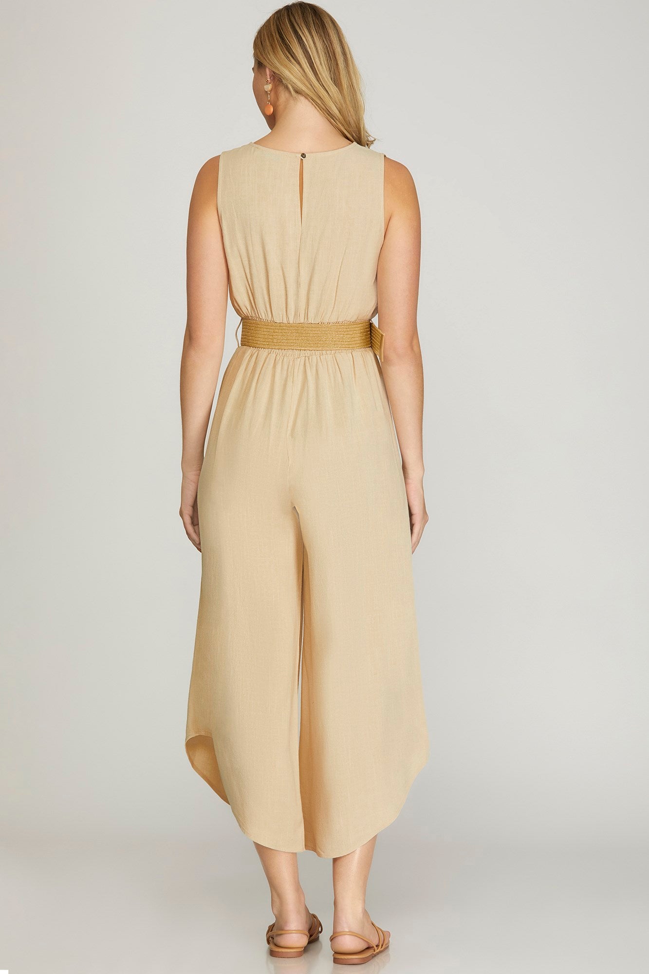 SLEEVELESS SURPLICE WOVEN JUMPSUIT WITH SMOCKED WAIST AND BELT DETAIL