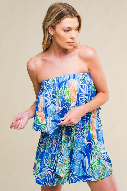 A printed woven romper featuring strapless, fully pleated